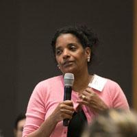 Patient advocate Adrienne Shapiro holds a microphone 