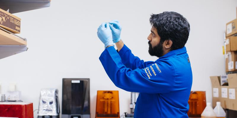A scientist examines a piece of bioengineering equipment in a lab