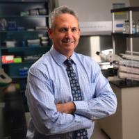 Researcher Michael Teitell smiles with crossed arms.