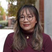 Female researcher with long hair wearing a maroon shirt. 