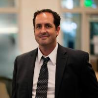 Researcher Robert Prins smiles in a suit 