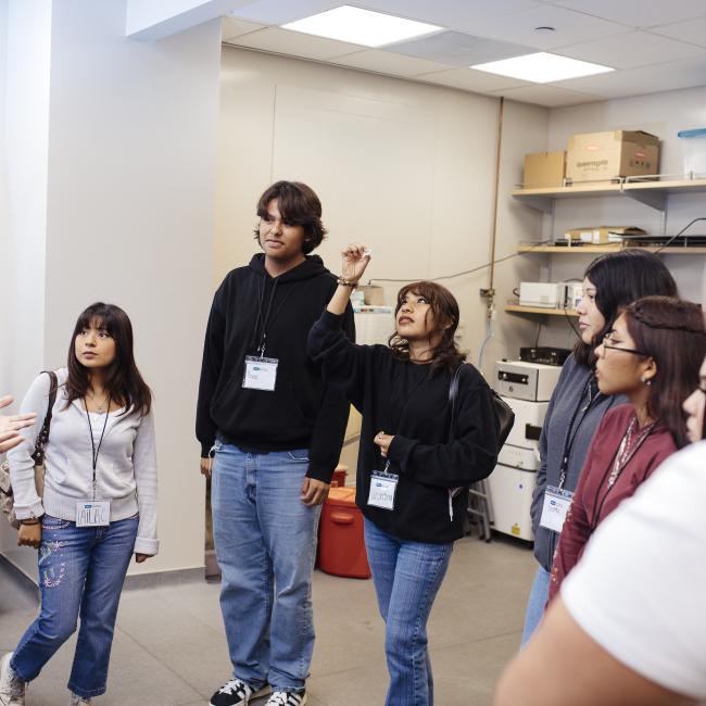 high school students in the microscopy core passing around a cell slide