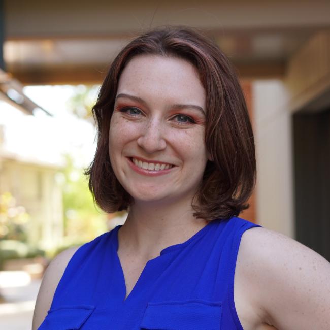 Female admin with shoulder-length hair in a blue shirt.