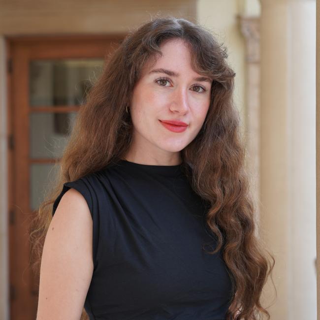 Female Admin with long brown hair wearing a black shirt.