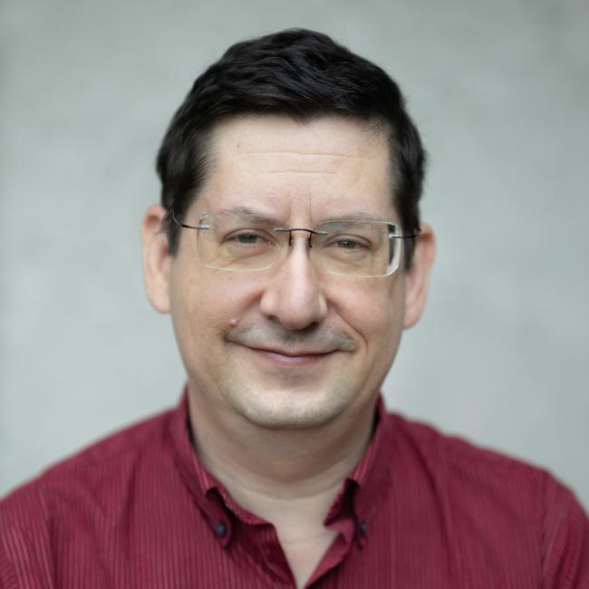 Male researcher with short dark hair wearing a red shirt.