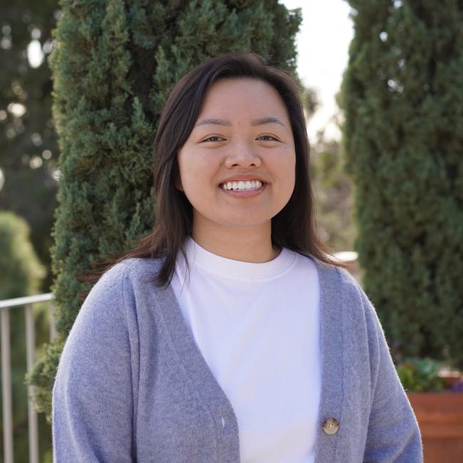 Headshot of BSCRC trainee Mary Doan, an individual with dark hair wearing a gray cardigan over a white top, smiling outdoors.