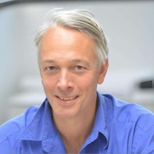 Alexander Hoffman smiles for a headshot.