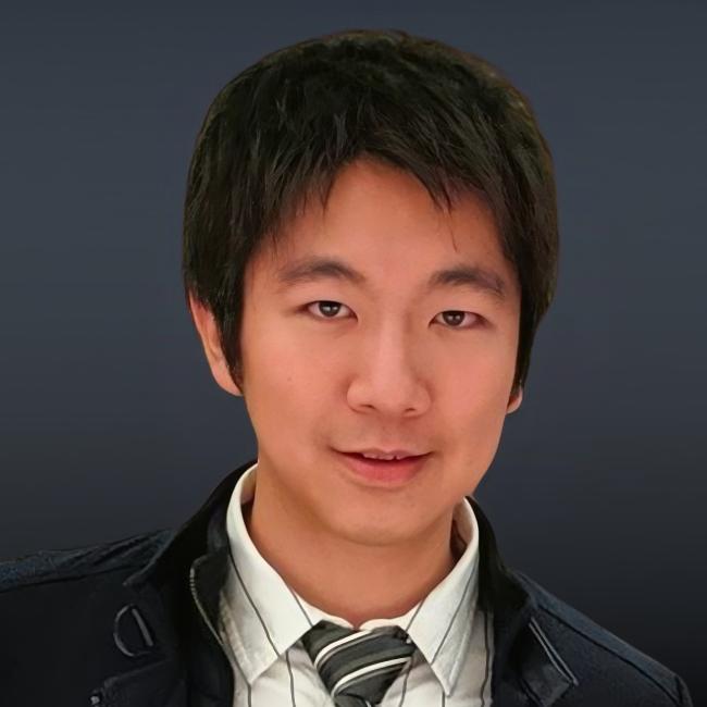 A headshot of Derek Lee, who is pictured against a black background wearing a striped dress shirt, a striped tie, and a black blazer. 