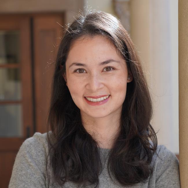 Female admin with medium-length, dark hair in a grey shirt.