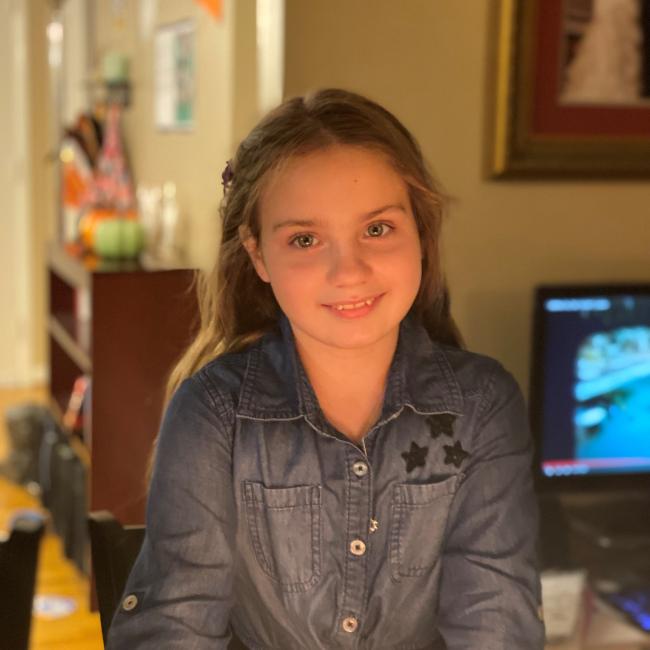 Eleven-year-old Eliana Nachem smiles in the glow of birthday candles