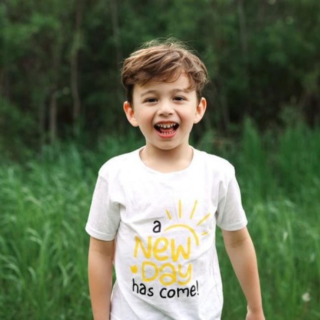 Jakob Guziak smiles in a grassy field.