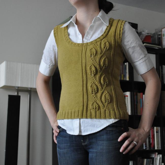 woman wearing a white shirt with a green knitted vest over