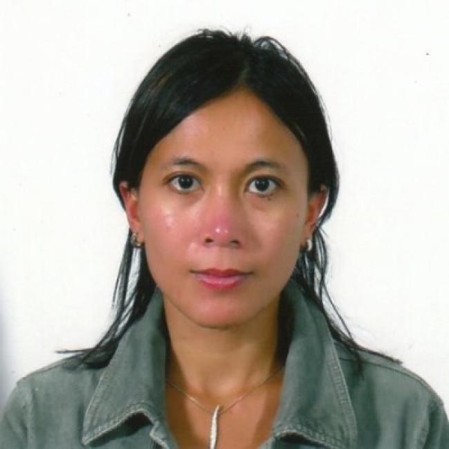 Headshot of Apriliana Kartikasari, a person with long dark hair, against a light background, wearing a gray jacket.