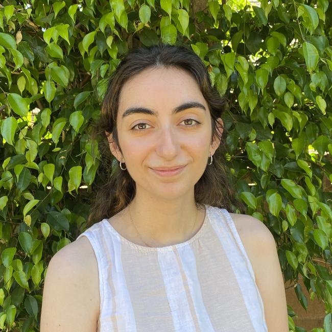 Female admin with medium-length, dark hair in a white shirt.