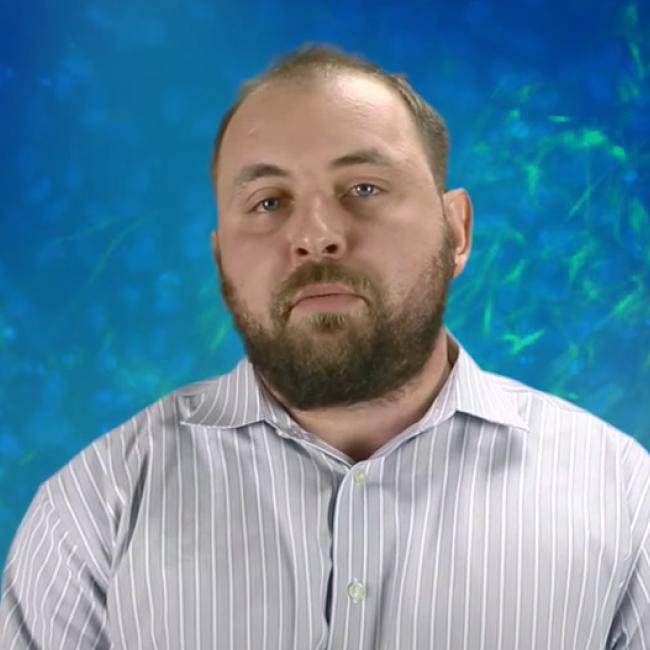 Alberti, Michael photographed against a blue background.