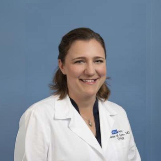 Researcher Renea Sturm smiles in a white coat.