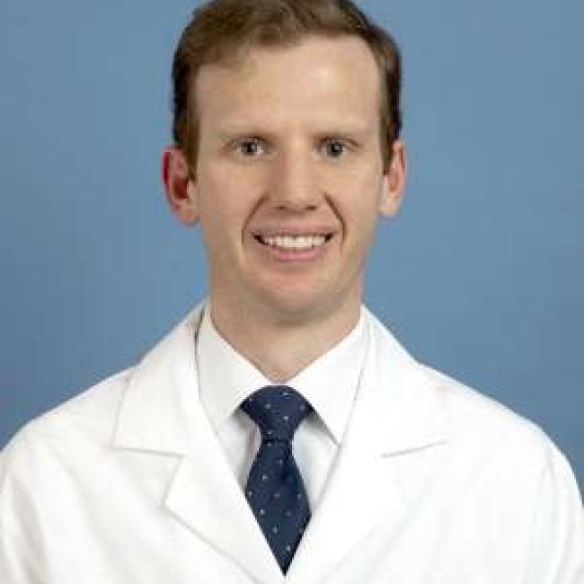 Paul Toste smiles for a headshot.